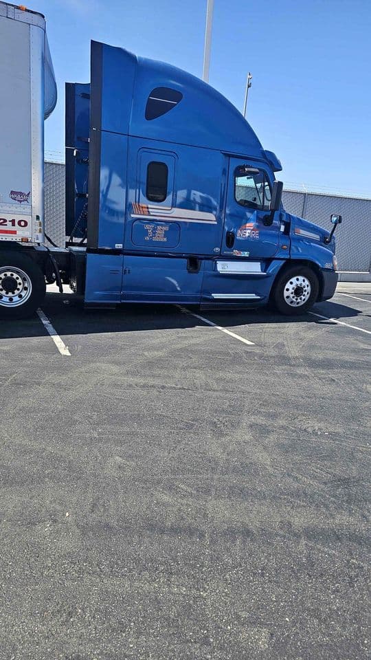 Driver side of tractor showing DOT numbers, mirrors, door, and fuel tank